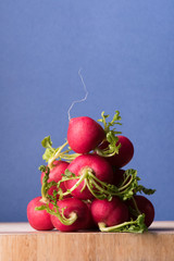 Bunch of radish on wooden board, fresh market vegetables.