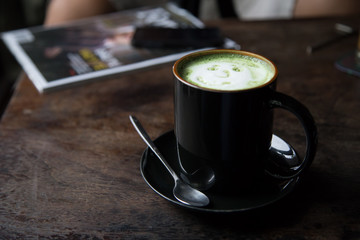 Cup of green tea latte on wood background