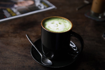 Cup of green tea latte on wood background