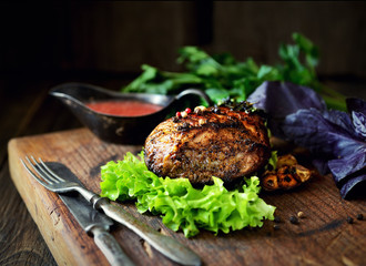 uicy grilled piece of meat on a cutting board, basil, parsley, spices
