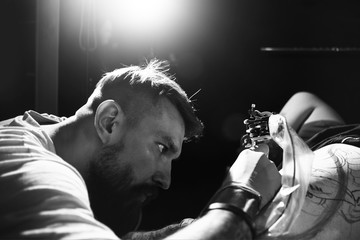 Tattooist makes a tattoo to the client