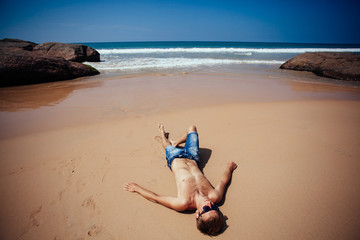 Shirtless male model sunbathing.Top view of  young man relaxing