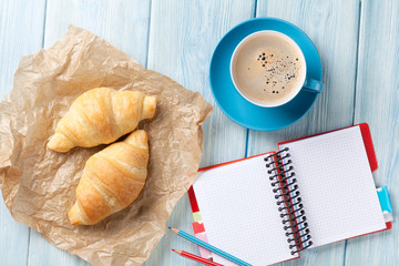 Fresh croissants, coffee and notepad