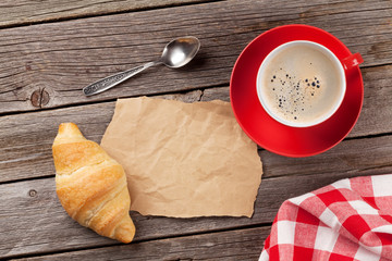 Fresh croissant and coffee on wooden table