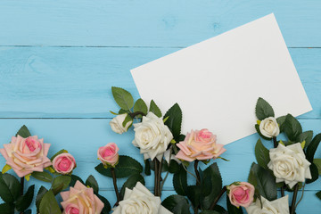 white blank card with flowers on a wooden blue background