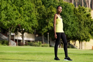 Fit young woman in sportswear standing in a park