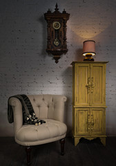 Still life of vintage beige armchair, yellow cupboard, wooden pendulum clock and illuminated table lamp on a wooden floor and white bricks wall