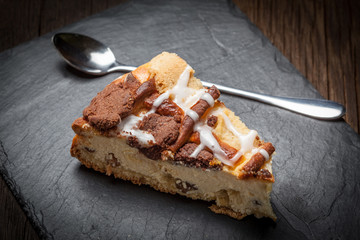 Cheesecake with raisins on a slate plate.