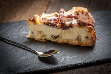 Cheesecake with raisins on a slate plate.