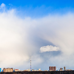 little snow cloud in large cumulus cloud over city