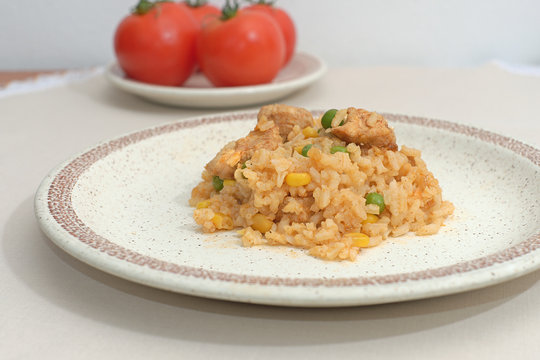 Homemade risotto with corn, peas and chicken on a plate