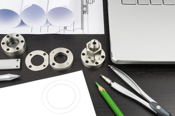 Drawings, components and design tools on the table of an engineer or designer illustrating research and development process in engineering and science. 