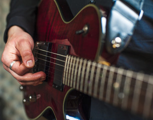 Closeup of man's hands playing on electric guitar