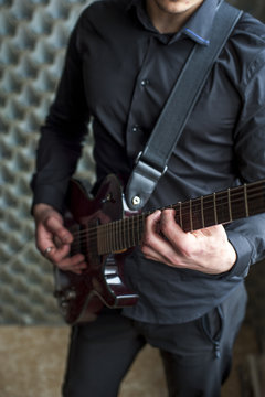 Young guitarist playing on electric guitar. Selective focus.