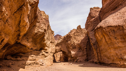 Fototapeta premium Sandstone Arch. Rocky landscape background. Wind and water did the bridge between the rocks. Natural bridge canyon trail, Death Valley