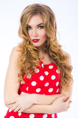 Portrait of young beautiful sexy girl with bright makeup. Face of the beautiful girl close up on a white background. Glamorous lady in red dress with polka dots.