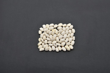 Square made from white beans on black background. Forms geometri