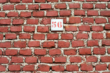 Fototapeta na wymiar Red brick wall background with number 56