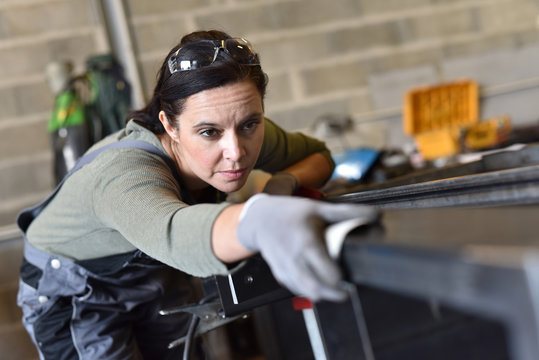 Metalworker Sanding Down Piece Of Metal