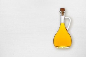 Olive oil bottle on white wooden table
