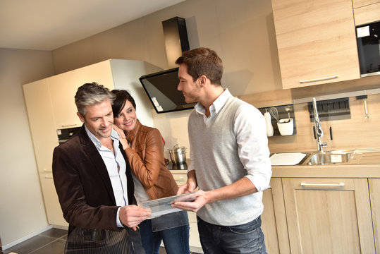 Kitchen furniture salesman giving advice to couple