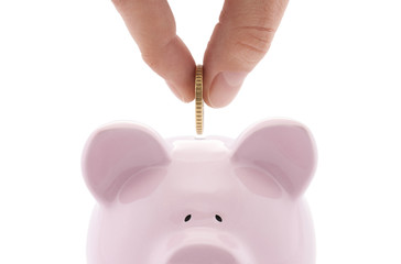 Putting coin into the piggy bank 