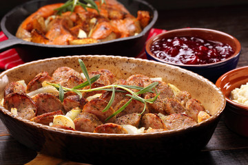 White sausages baked with garlic and onion in a bowl