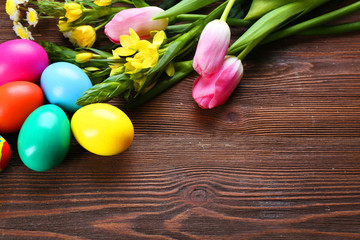 Obraz na płótnie Canvas Easter eggs with spring flowers on wooden background