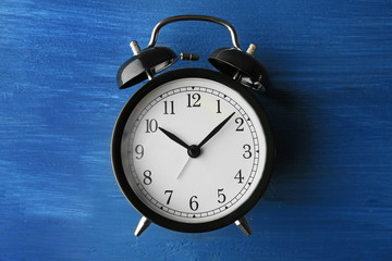 Alarm clock on old wooden table.