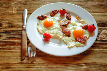 fried sausages and eggs on a red-hot frying pan