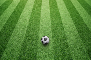 Sunny artificial green football grass with soccer ball background. Soccer game copy space background.