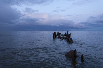 Fototapeta na wymiar Old stone jetty at sea on a summer evening.