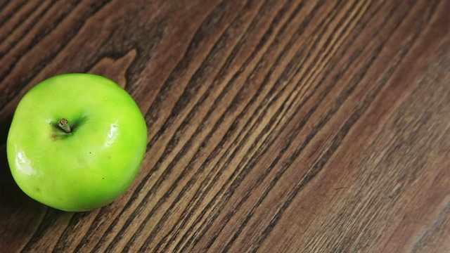 Green apple on the table rotates. Full HD