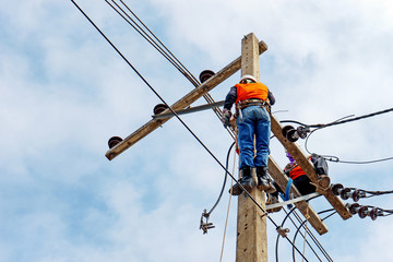 Electrician lineman repairman worker at climbing work on electric post power pole, Thai language same safty fist in English language