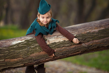 Cute little boy dressed as a Robin Hood playing in the woods