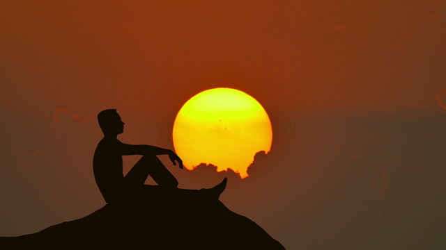 3 in 1! The man sit on the rock against the sunset. Time lapse