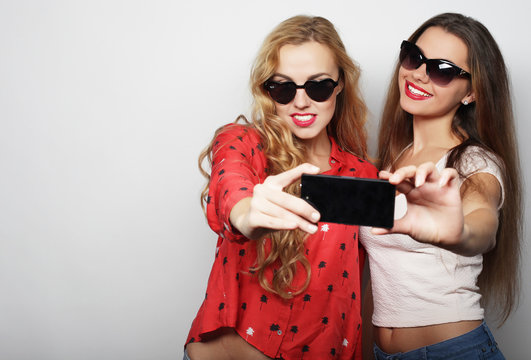 Two teenage girls friends in hipster outfit make selfie 