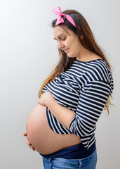 Pregnant woman in long hair holding belly