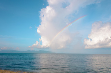 Rainbow over horizon of ocean beach