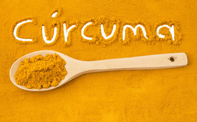 Turmeric powder and wooden spoon