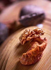Walnut kernel and dried fruits on a wooden board