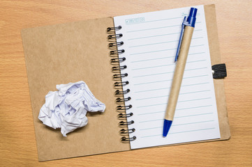 crumple white paper and pen on notebook