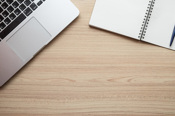 office table with laptop, notebook and pen on wooden table