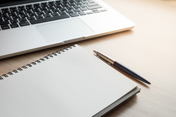 close up office table with laptop, notebook and pen on wooden ta