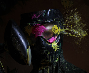 Splashes after direct hit to protecting mask in the paintball game - obrazy, fototapety, plakaty