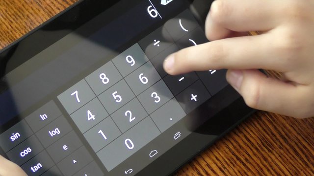 Child makes arithmetic calculations with a calculator