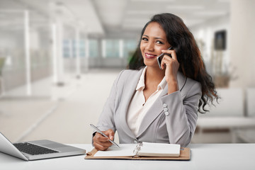 Cheerful pretty business executive talking on the phone