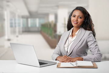Portrait of business lady in headset consulting a client