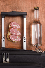 Black suitcase, a bottle of vodka and food