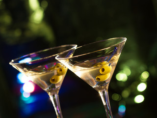 Two glasses with martini , focus on a olives